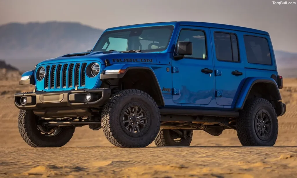 Blue Jeep Wrangler front profile in rough terrain