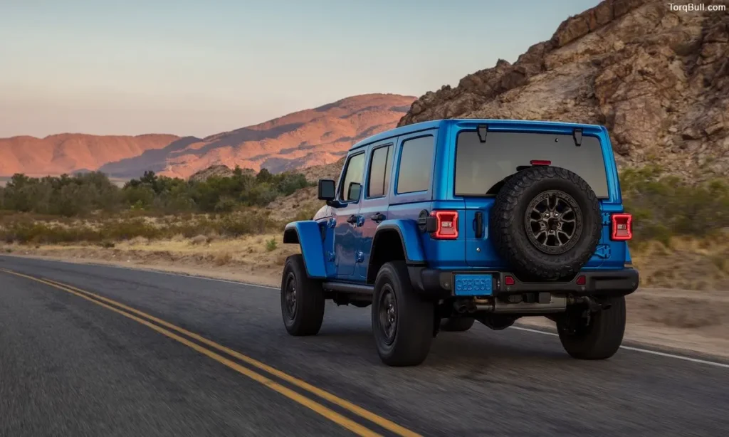 Blue Jeep Wrangler rear profile on highway
