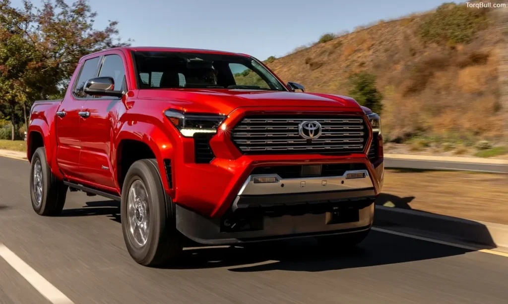 Red Toyota Tacoma on road in mountain