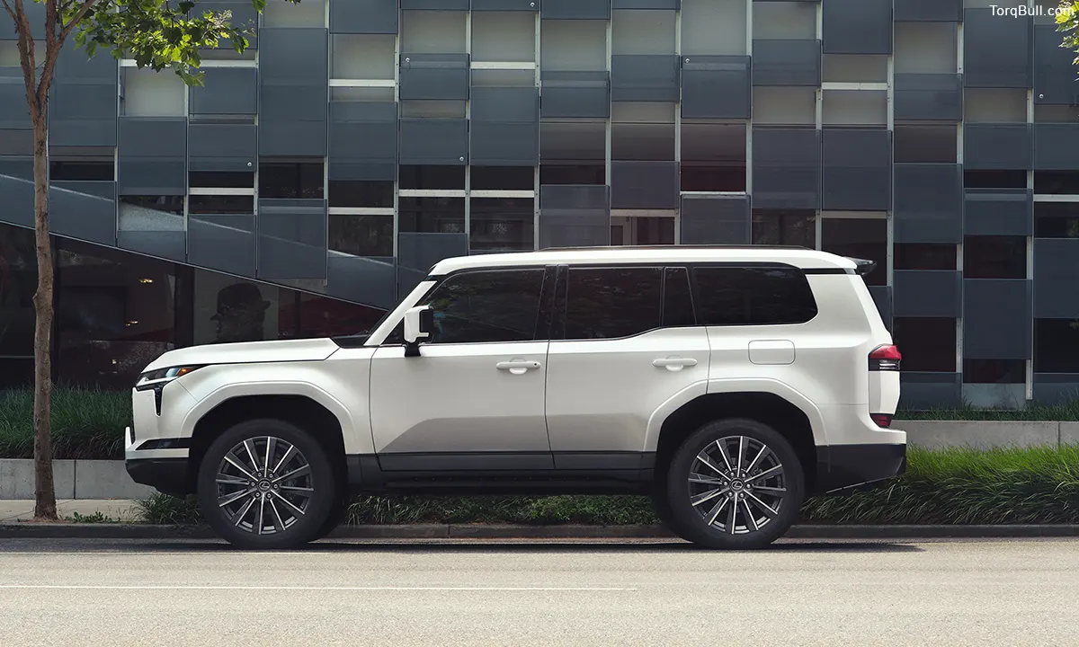 White Lexus GX side view parking near black building