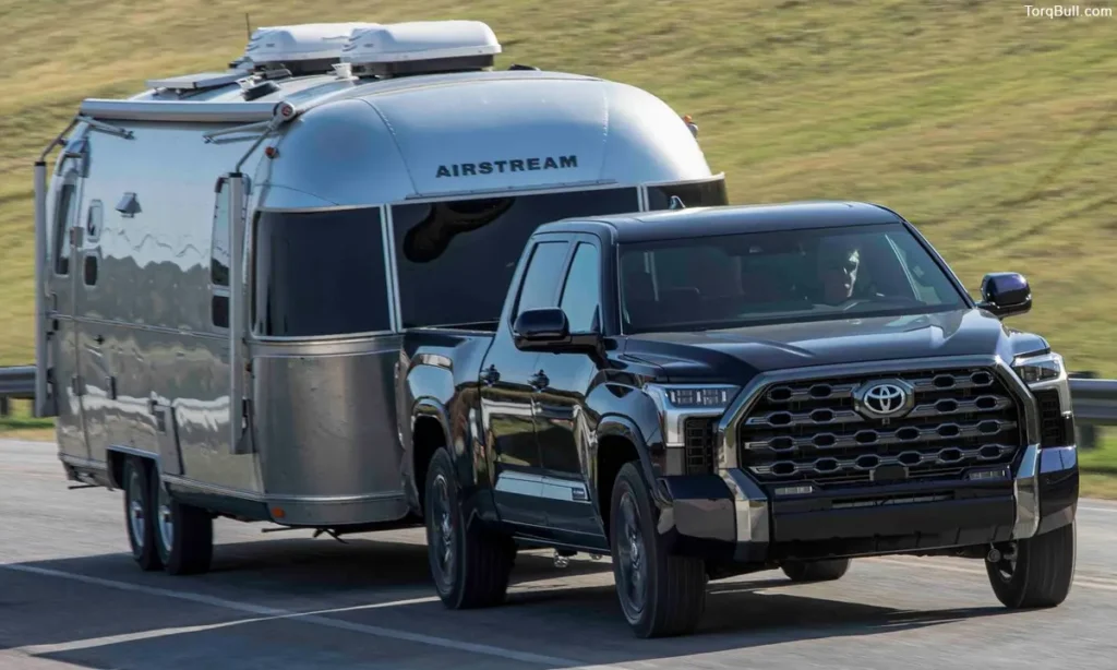 Blue Toyota Towing a Trailer on road